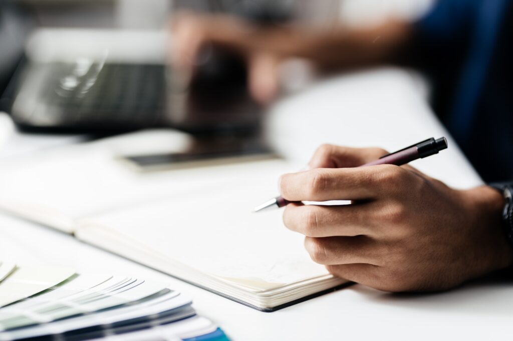 Man makes notes in a notebook on a table